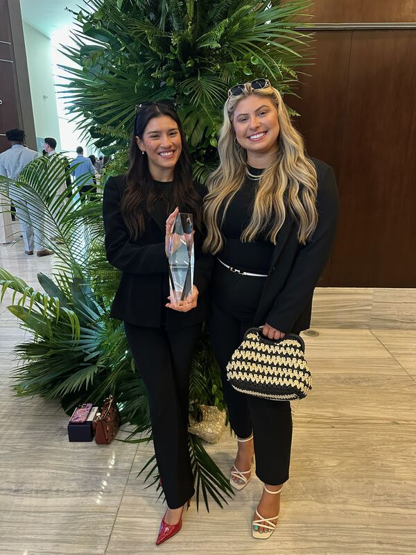 Two Skyline Marketing Agency team members holding an award